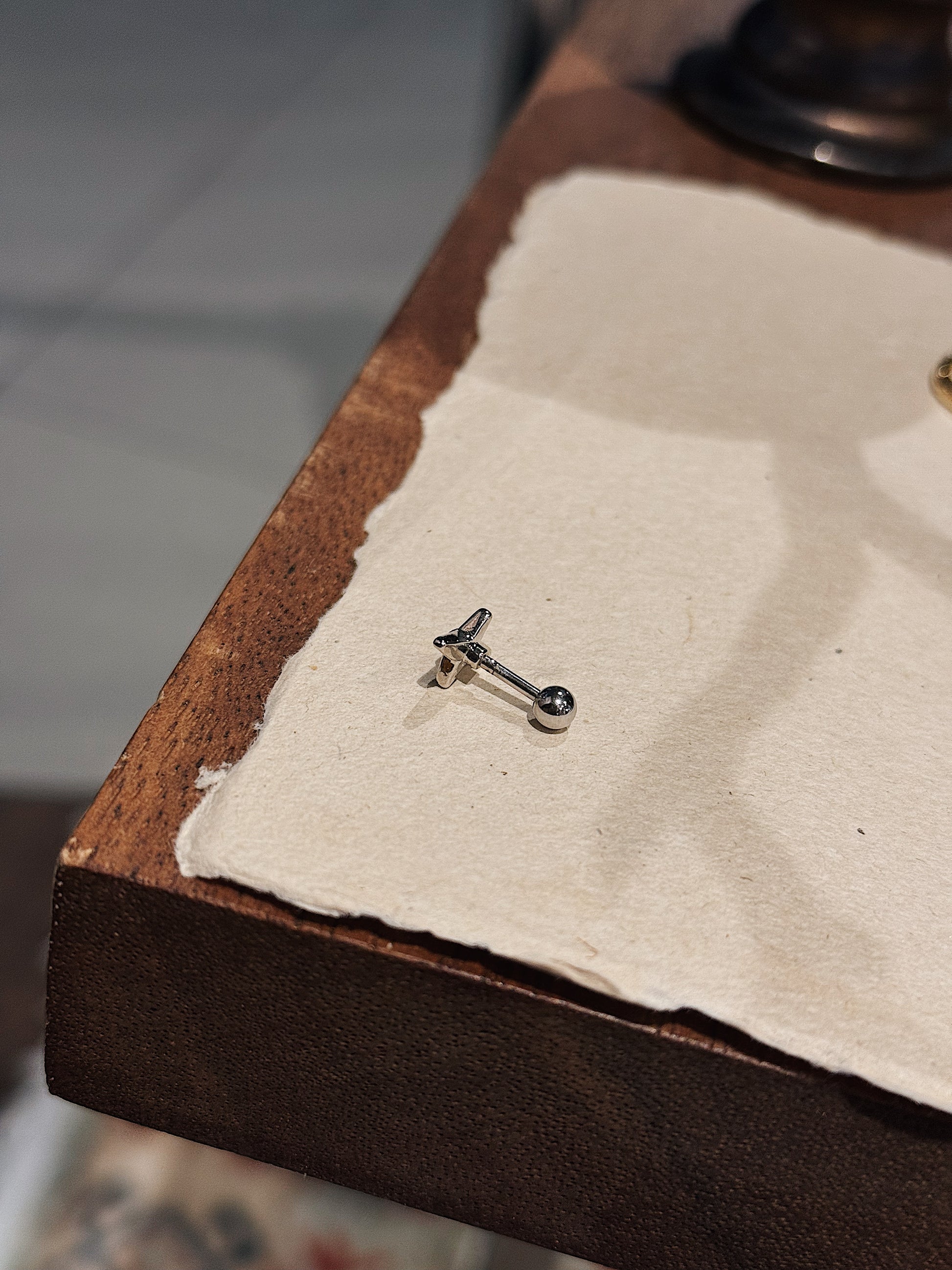 Stud cross barbell piercing