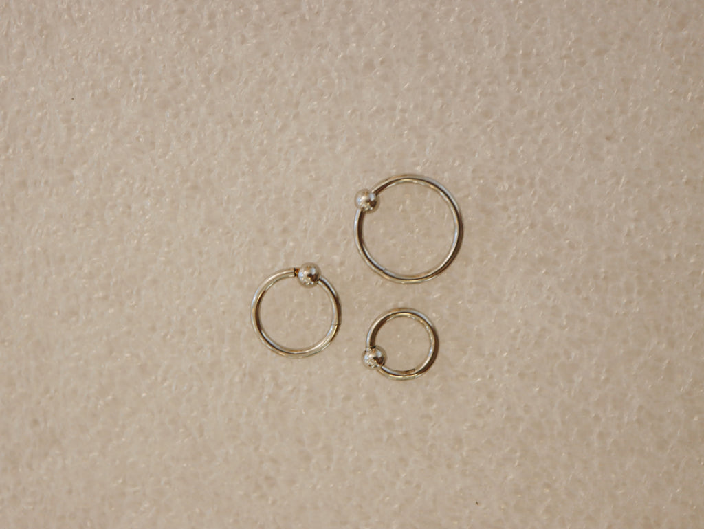 Surgical steel captive bead clicker