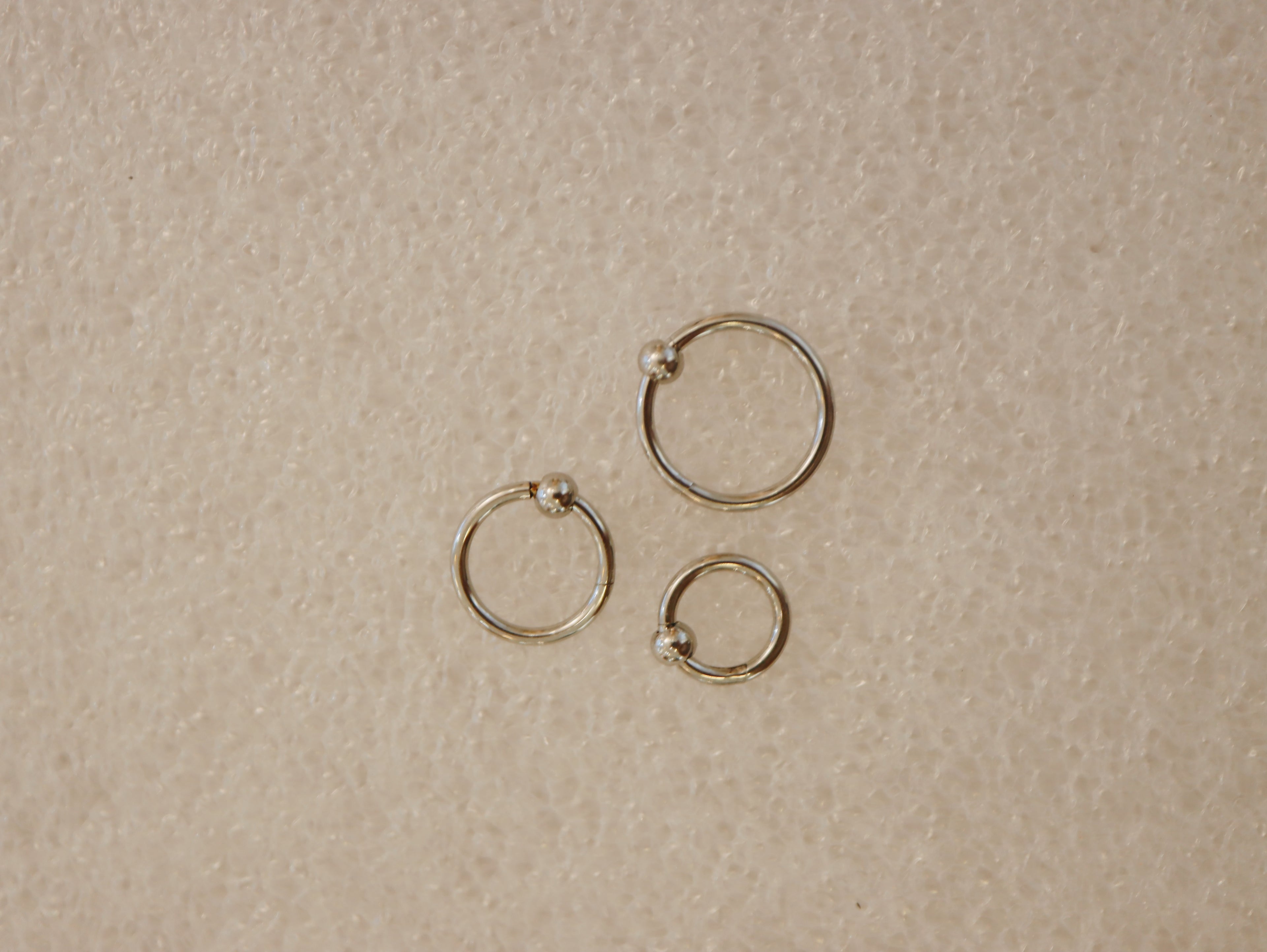 Surgical steel captive bead clicker