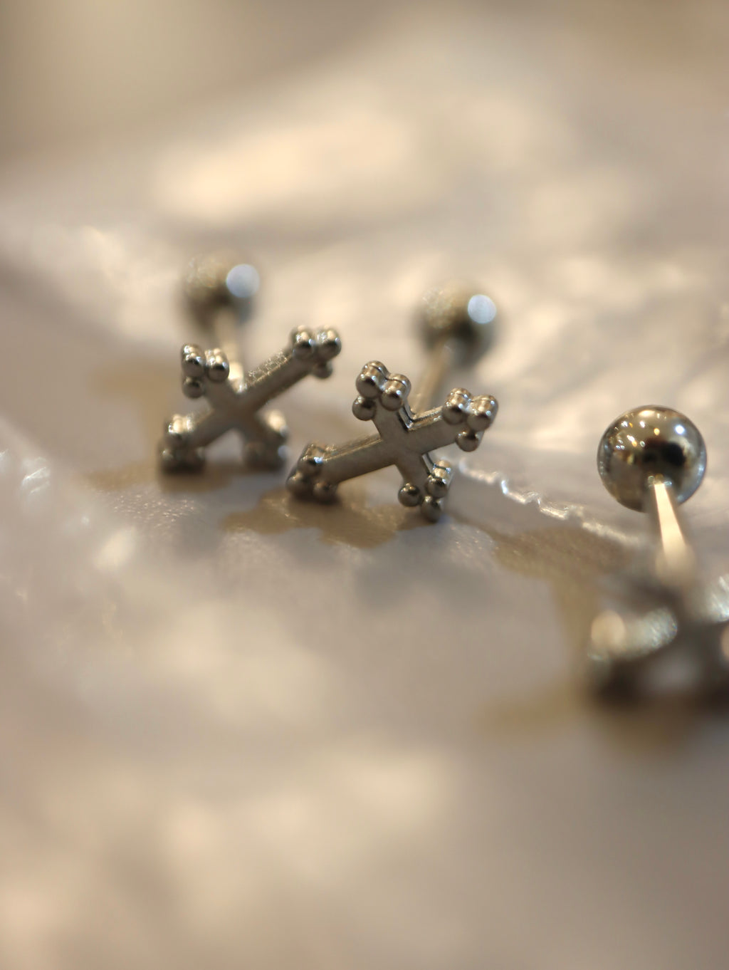 Cross surgical steel piering stud