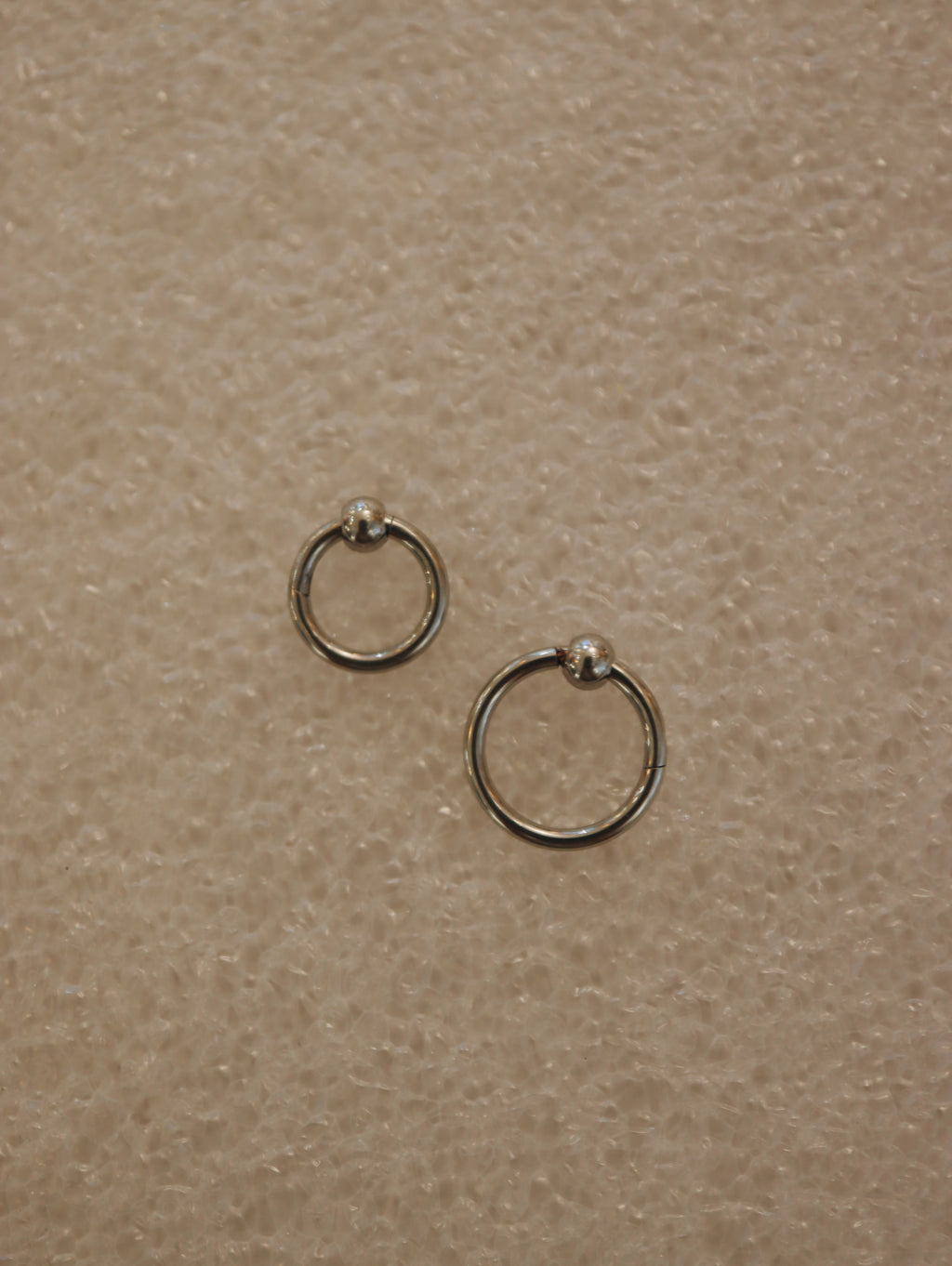 Surgical steel captive bead clicker