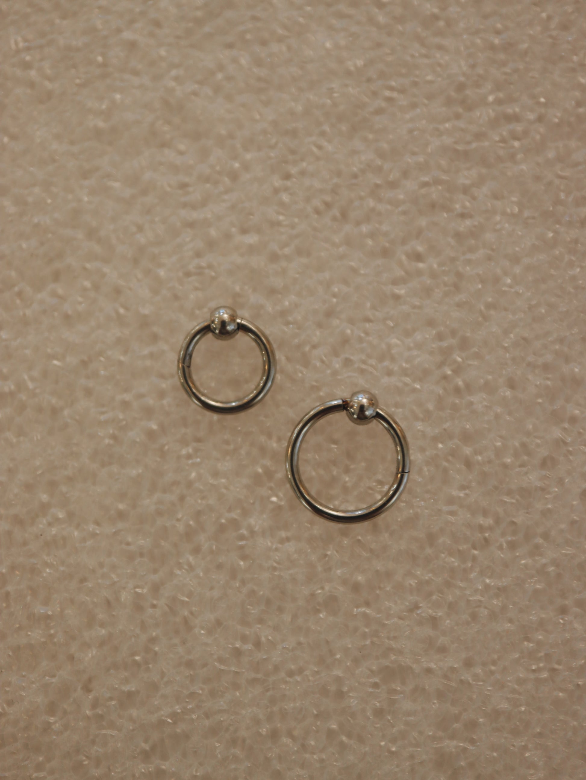 Surgical steel captive bead clicker