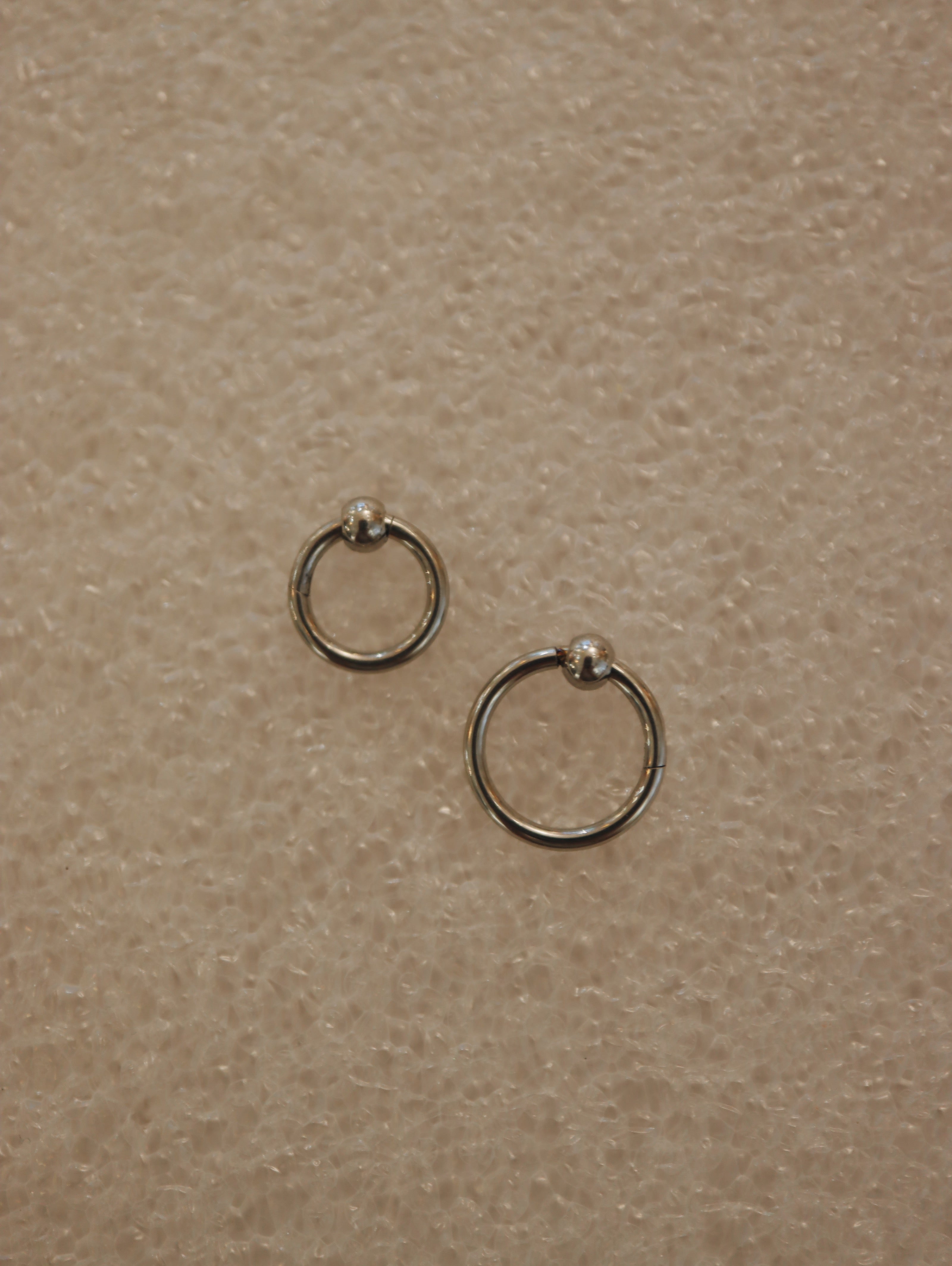 Surgical steel captive bead clicker